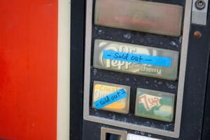 Zeigt einen Getränkeautomaten bei dem einige Getränke ausverkauft sind.